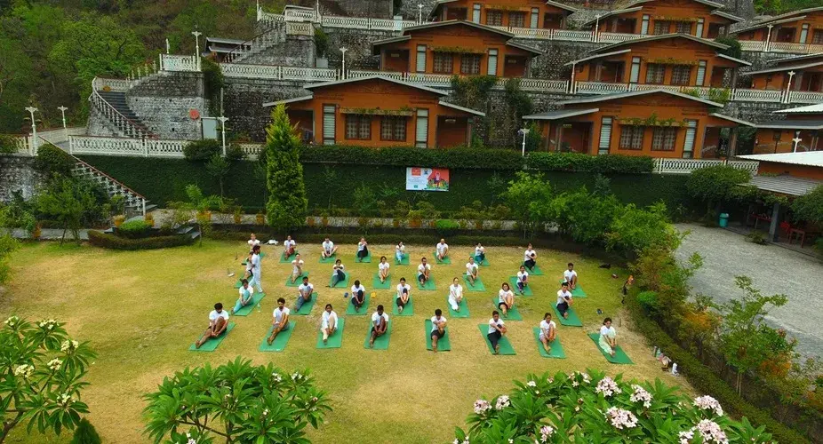 Students practising yoga on the lawn at Abhayaranya Yoga Ashram, Rishikesh