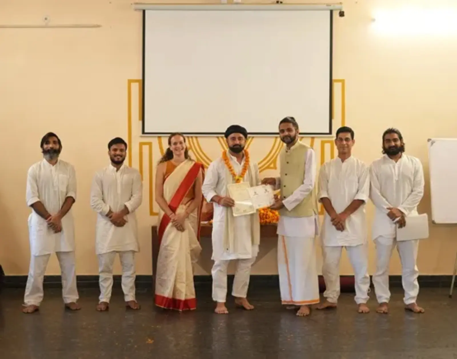 Certificate ceremony with teachers and a graduating student at Rishikesh Yogpeeth