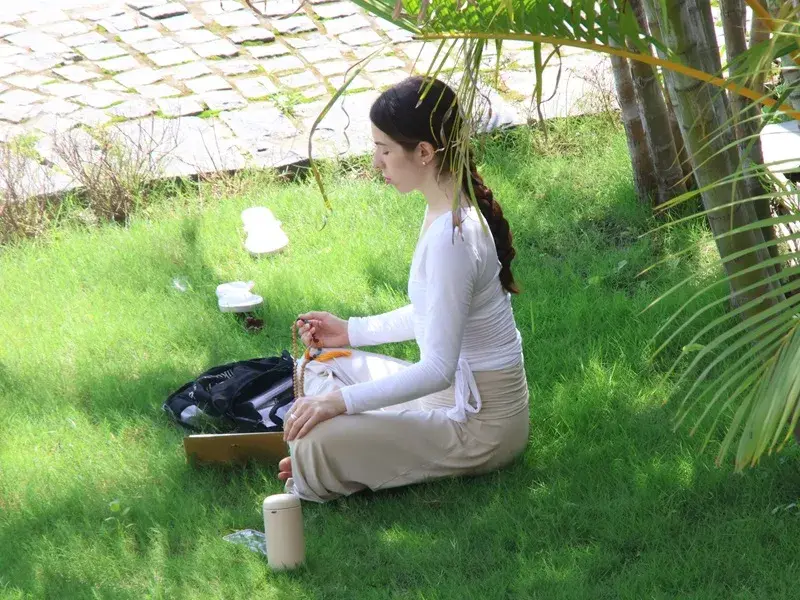 Student seated in meditation on the lawn at the ashram