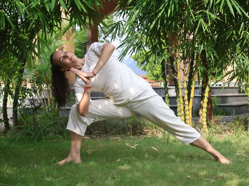 Student in extended triangle pose in the ashram garden