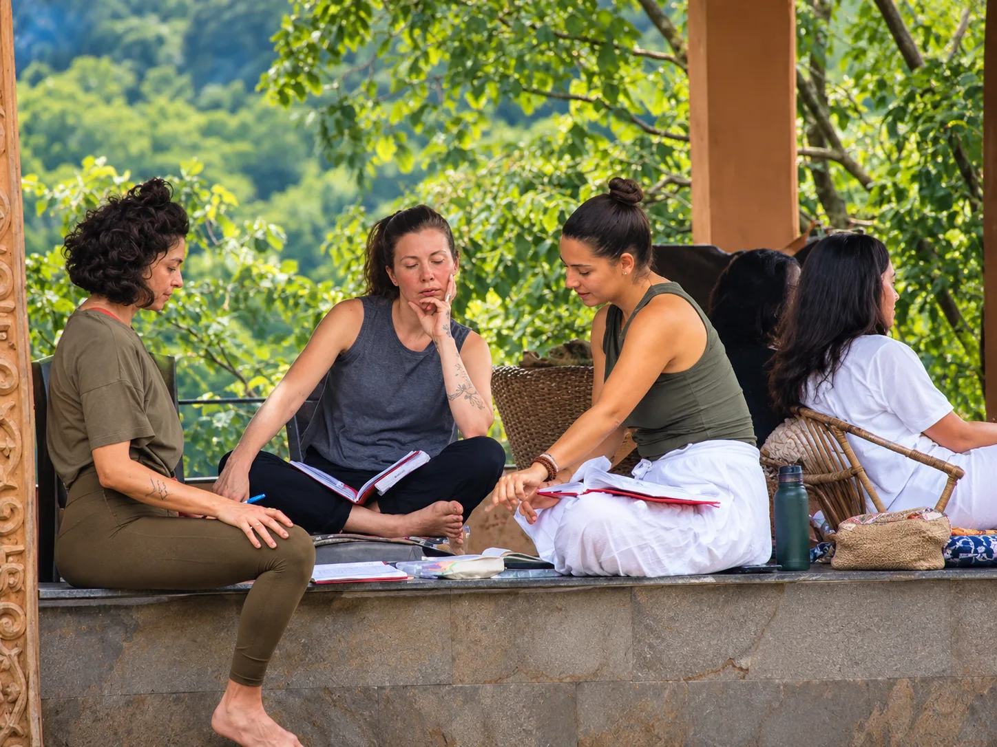 International students sitting in a circle holding hands on the ashram lawn