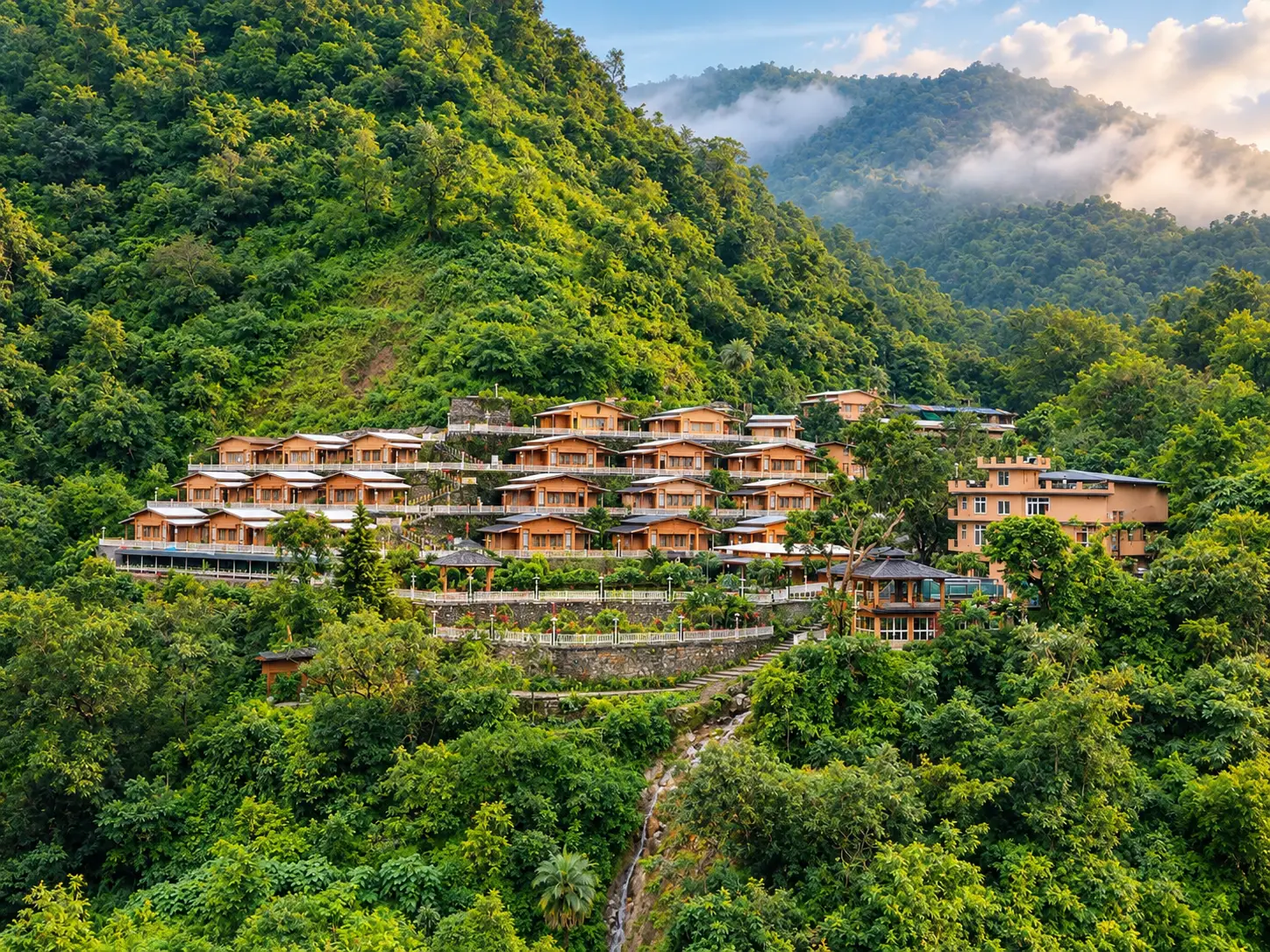 Ashram cottages terraced into the green hillside above the valley