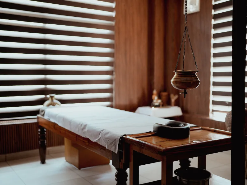 Ayurveda therapy room with two wooden droni massage tables at the ashram in India