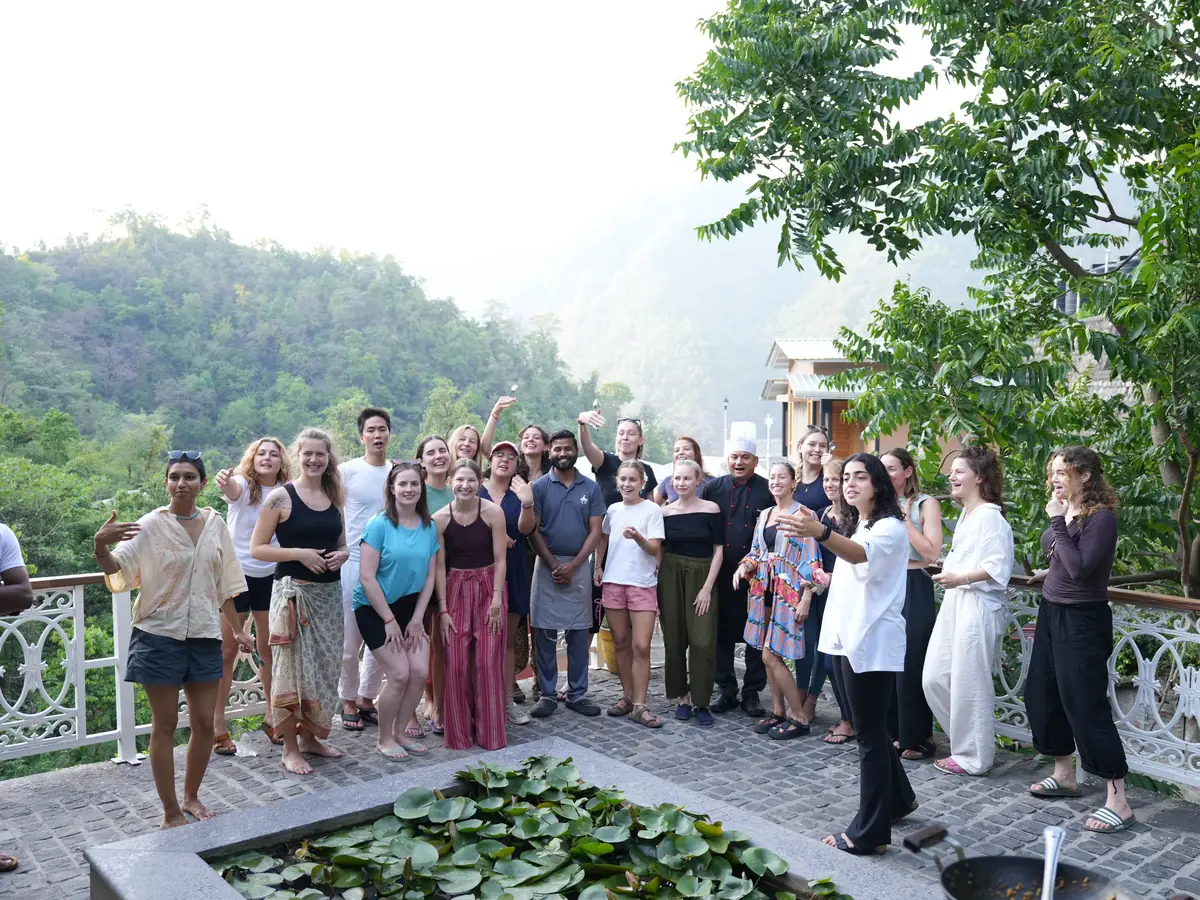 Students and the ashram chef together on the lily pond terrace after a cooking class