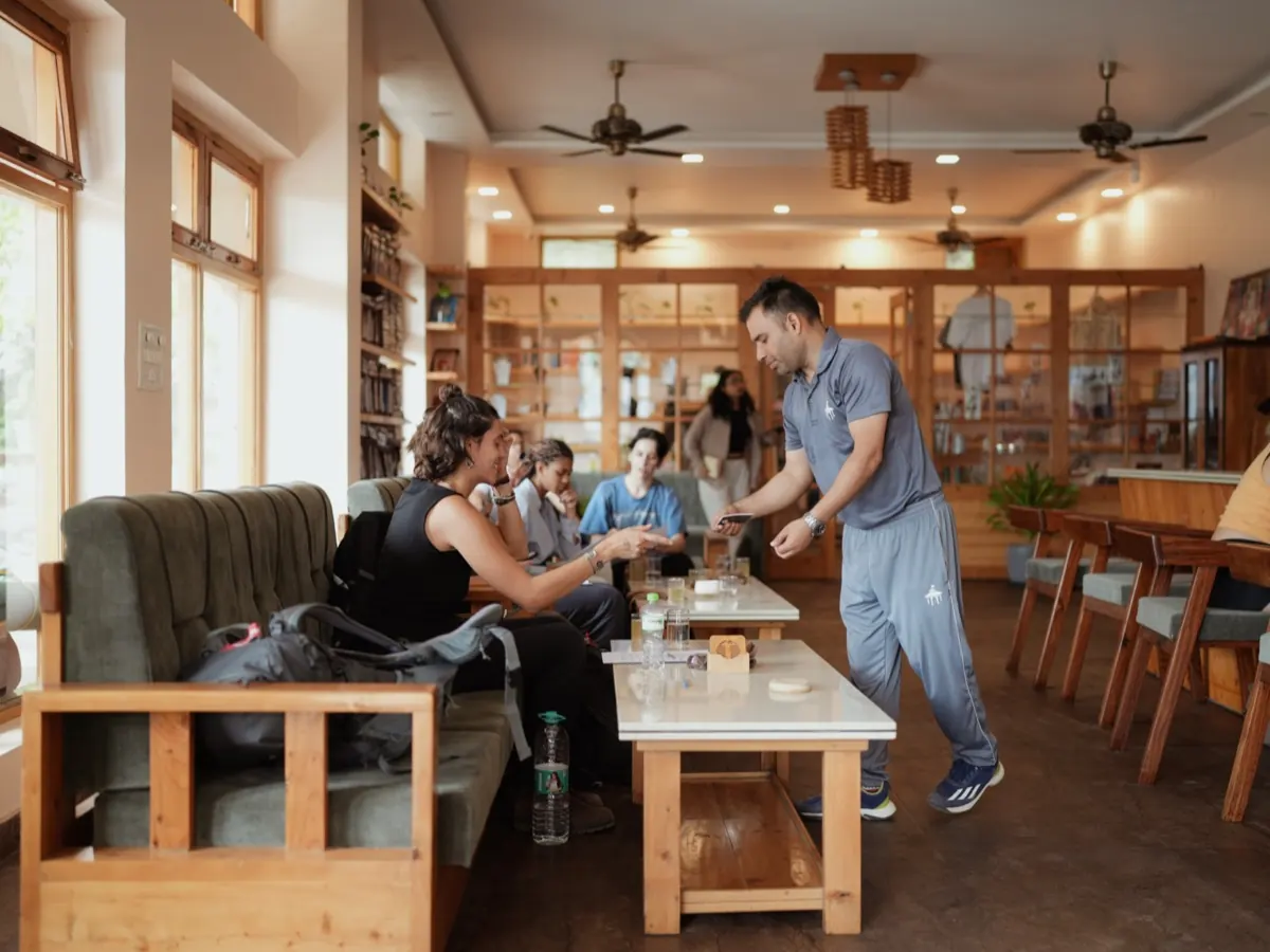 A teacher serves tea to students in the ashram library lounge
