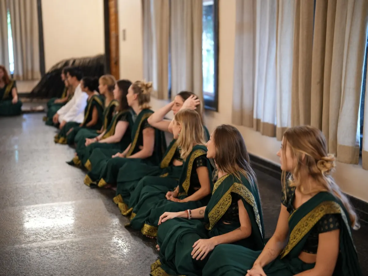 Students listen to each other in a sharing circle in the yoga hall