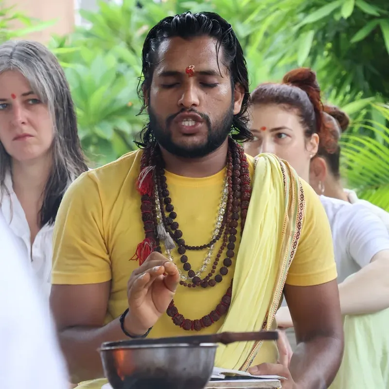 Teacher chanting with a singing bowl in front of students