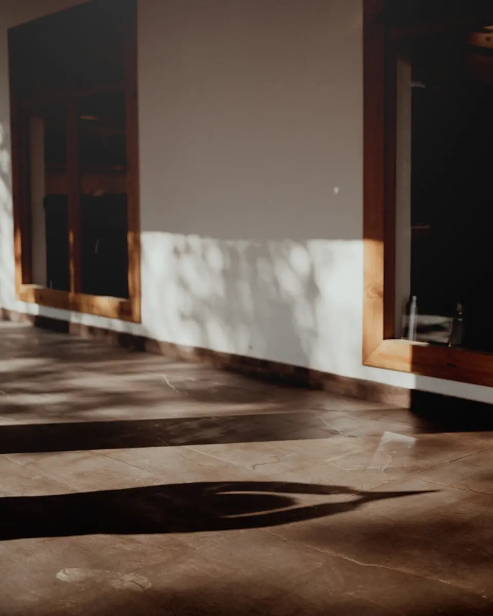 Morning light and leaf shadows on a quiet, empty veranda at the ashram