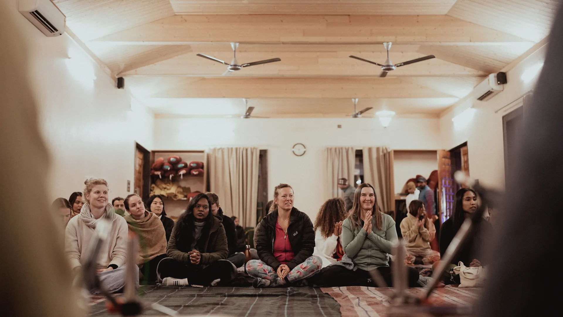 Students seated in a circle on the floor of the yoga hall during a satsang at the ashram in Rishikesh