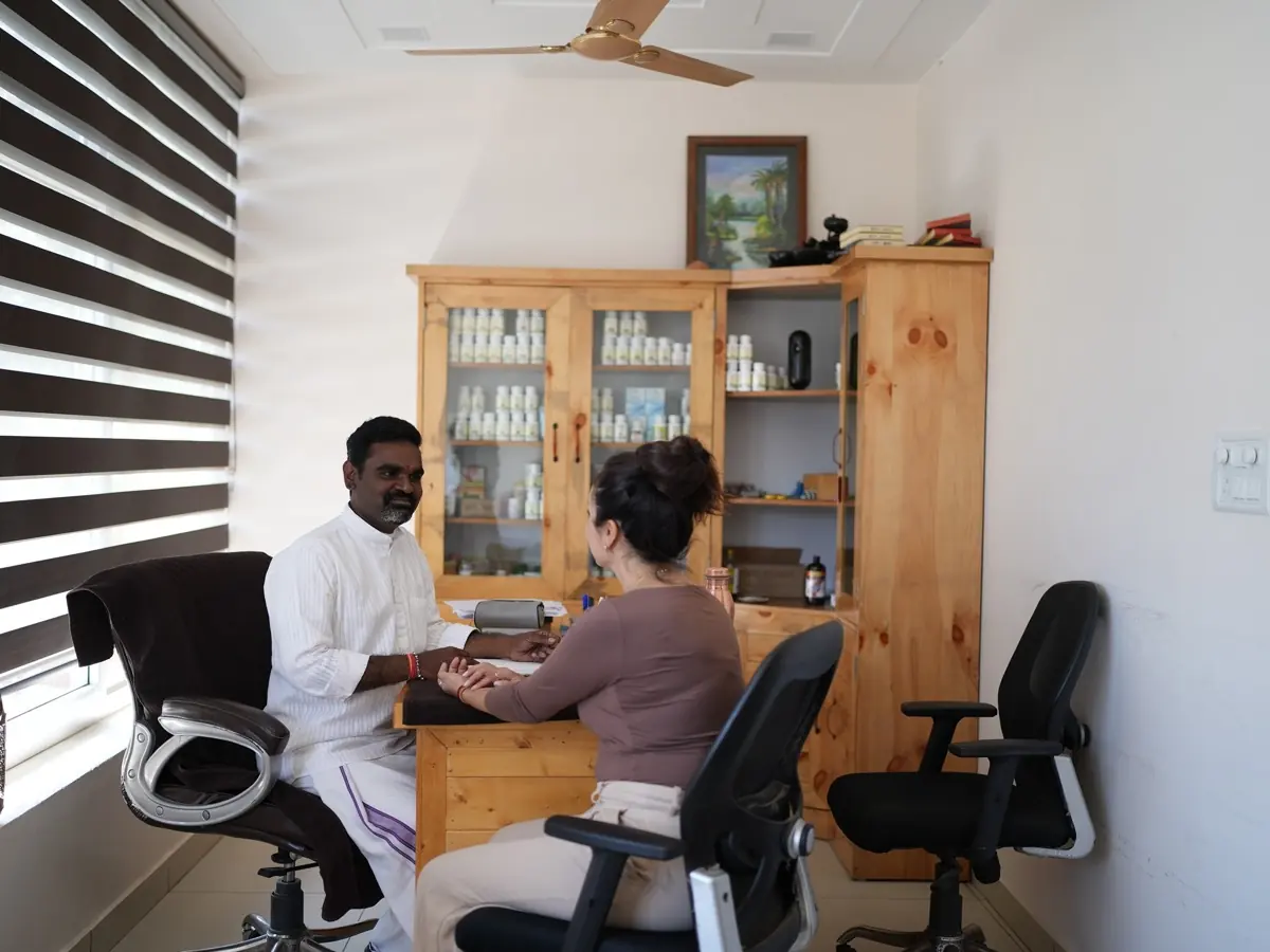 The Ayurvedic doctor reads a student's pulse in the consultation room